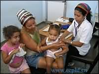 在古巴的诊所，一名卫生工作者在为一个女孩做检查。