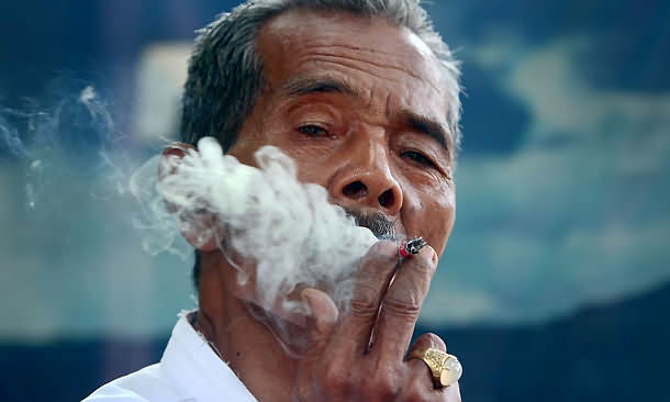 A man smokes a cigarette in Medan, Indonesia